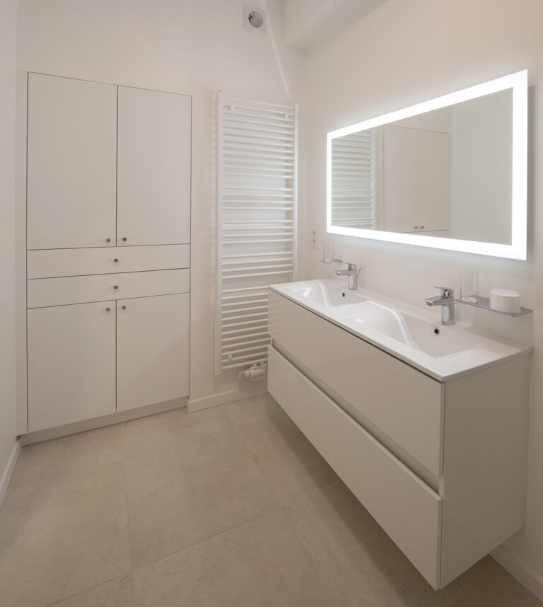 Salle d’eau rénovée à Ixelles (Bruxelles) avec douche, double vasque et carrelage gris